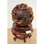 A 19th/20th Century Chinese carved hardwood Zodiac ball, featuring a dragon and raised on a hardwood