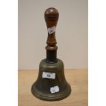A 19th/20th Century hand held bell with turned wood handle, measuring 25cm high