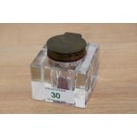 A cut glass ink well of cube form with bevelled edges and metal lid, measuring 6cm high