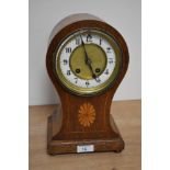An Edwardian balloon shaped mantel clock, the oak and satinwood inlaid case enclosing an enamelled