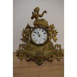 A late 19th Century French gilt metal mantel clock with key, having a figural surmount above an