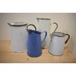 Four mid-20th Century enamelled kitchen jugs to include a mottled blue jug, the largest measures