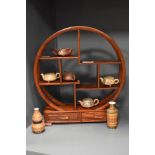 A Chinese stained wood display stand of circular form with a selection of terracotta and glazed