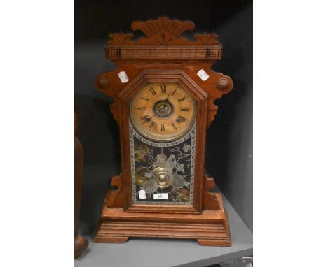 A late 19th Century American Gingerbread mantel clock by the Ansonia Clock Company, the mahogany case and etched glazed door 