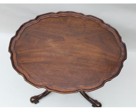 A GEORGIAN DESIGN MAHOGANY OCCASIONAL TABLE, oval pie crust rim top, raised on turned and lobed stem on arched tripod support