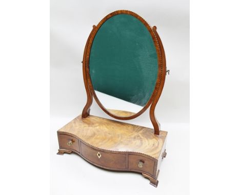 A 19TH CENTURY MAHOGANY BOX BASE TOILET MIRROR, having oval mirror, on serpentine base fitted with three drawers, raised on o