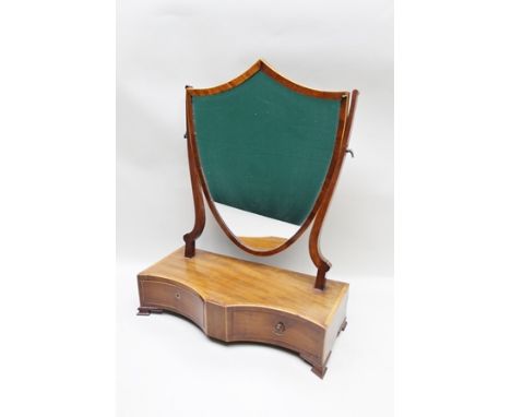 A 19TH CENTURY MAHOGANY BOX BASE TOILET MIRROR, having shield framed plate, on a two-drawer box base, raised on ogee bracket 