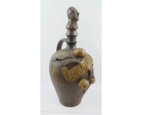 A LATE 19TH CENTURY "CALVADOS" STONEWARE DECANTER with handle and stopper, the stopper formed as the bust of a man, having ap