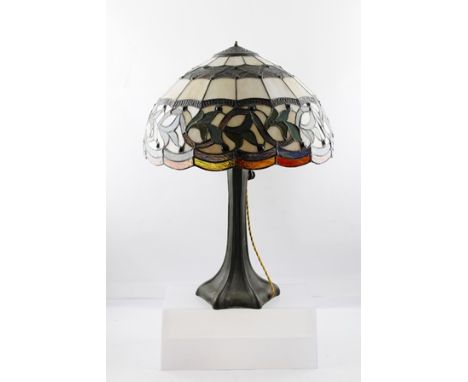 A "HANDEL" ART NOUVEAU DESIGN TABLE LAMP having bronzed tapering base, impressed "Handel", with leaded glass decorative shade