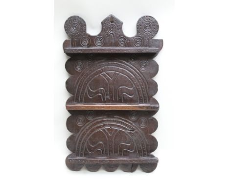 A PART 18TH CENTURY SPOON RACK, having carved initialled and shaped plank back over three pierced shelves, 46cm high 