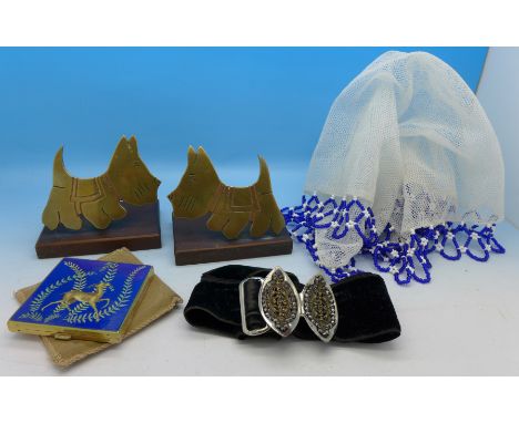 A pair of brass and Bakelite Scottie Dog figures, a French cut steel buckle and velvet belt, a beadwork tablecloth and a comp