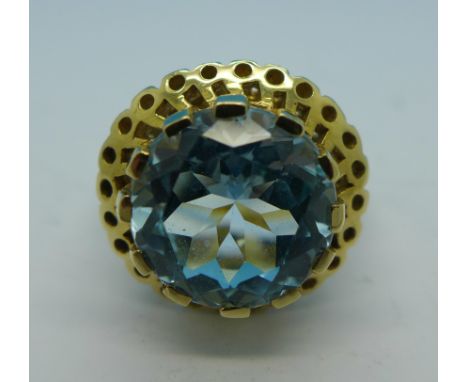 A 9ct gold ring set with a large blue topaz, 7.3g, N, 12mm diameter