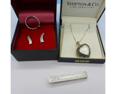 A pair of silver earrings set with diamonds, a silver ring, a silver locket and a silver tie clip