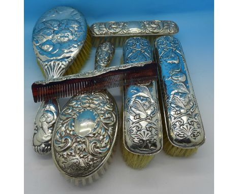 Five silver backed brushes and a comb