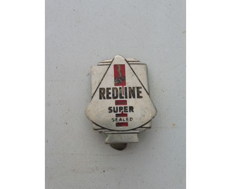 A Redline Super globe shaped lapel badge. 