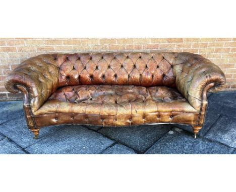 A BUTTON UPHOLSTERED LEATHER CHESTERFIELD SOFA  with scroll arms and serpentine seat, suitable for reupholstery Condition Rep