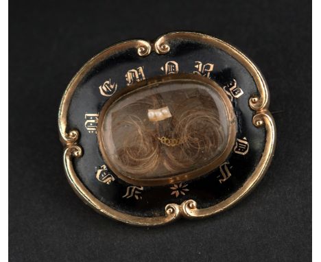 A MID VICTORIAN MEMORIAL BROOCH the black enamel brooch set with a glass fronted compartment containing hair coils, three see