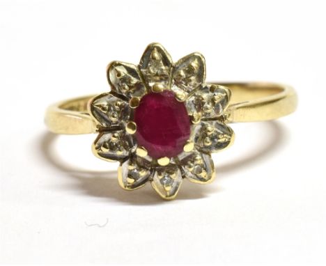 A 9CT GOLD, RUBY AND DIAMOND FLOWER HEAD RING  The faceted oval ruby measuring approx. 0.5cm by 0.4cm on a white metal diamon