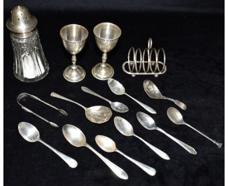 A COLLECTION OF SILVER  Comprising a silver toast rack 9cm in length Assorted silver spoons to include caddy spoon, sugar nip
