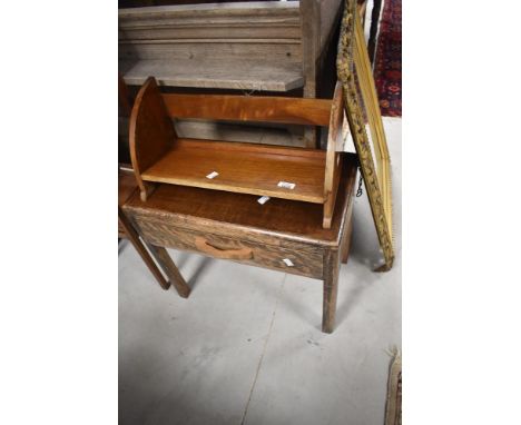 A vintage mahogany book trough and an early 20th Century oak occasional table/stool with drawer