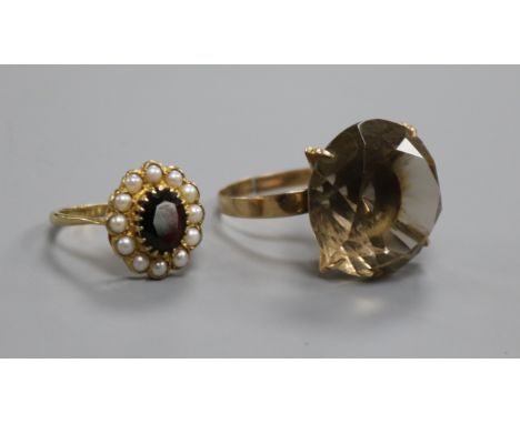 A 9ct gold and smoky quartz dress ring and a 9ct gold garnet and seed pearl oval cluster ring.