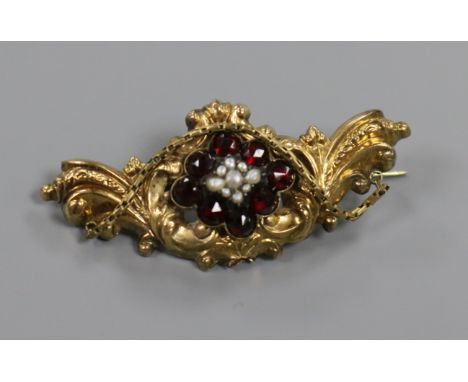 A late Victorian, yellow metal, garnet and pearl scroll brooch, 52mm.
