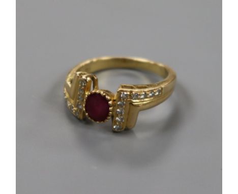 A modern 18ct gold and ruby set ring, with diamond set setting and shoulders, size M.