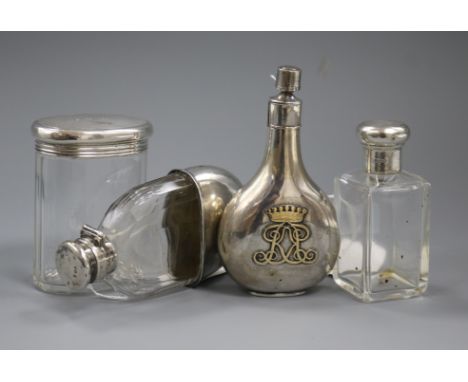 A silver perfume flask with monogram, two silver-mounted toilet bottles and a silver-mounted glass hip flask