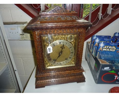 AN OAK CASED MANTLE CLOCK, gilt brass dial with silvered chapter, fast/slow and chime/silent rings, on German brass twin barr