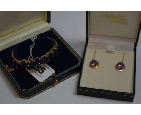 A SYNTHETIC COLOUR CHANGE SAPPHIRE BRACELET, with graduated oblong shape stones to the plain clasped bangle, with safety chai