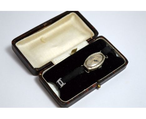 AN EARLY 20TH CENTURY WATCH, with oval shape face and sapphire cabachon winder