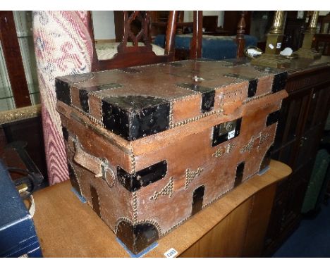 A LEATHER COVERED METAL BOUND AND STUDDED TRAVELLING TRUNK, H. Greaves, Birmingham label to underside of top (s.d.)