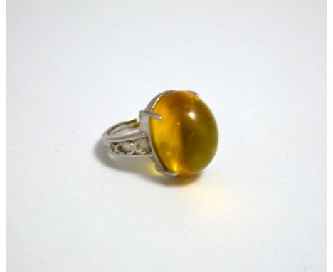 A LARGE BURMESE AMBER RING, with oval shape cabachon amber to the white metal mount, stamped 925, ring size M 1/2
