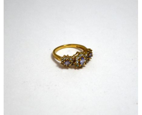 A 9CT GOLD TOPAZ RING, comprising of three daisy shape clusters to the plain tapered band, hallmarks for Birmingham, ring siz