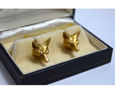 A PAIR OF CUFFLINKS, designed as a foxes head with ruby eyes stamped 14K
