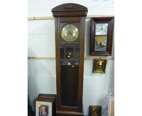 AN OAK LONGCASE CLOCK, with glass door and circular embossed brass face (pendulum and two weights)