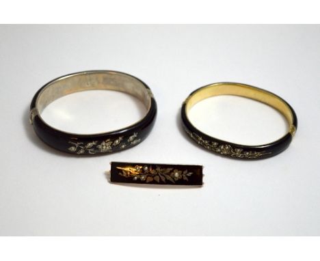 THREE TURN OF THE CENTURY ITEMS OF MOURNING JEWELLERY, to comprise of two black enamel bangles with white split pearls in flo