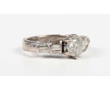 A white gold and diamond ring, claw set with the principal circular cut diamond between baguette cut diamond five stone taper