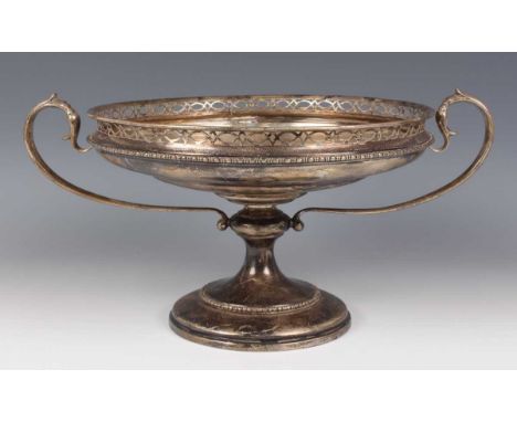 A George V silver table centrepiece tazza of shallow circular form with pierced rim above a baluster stem, flanked by scroll 