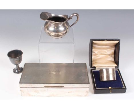 An Elizabeth II silver engine turned cigarette box, Birmingham 1964, length 17.5cm, a silver napkin ring, cased, a silver egg
