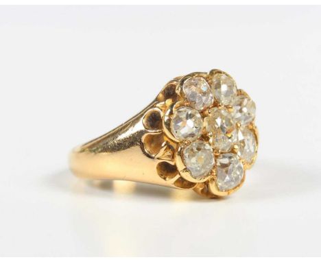 A gold and diamond cluster ring, claw set with a central old mine cut diamond within a surround of seven further old mine cut