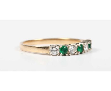 A gold, emerald and diamond ring, claw set with three circular cut emeralds alternating with four circular cut diamonds, deta