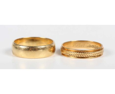 An 18ct gold wedding band ring, London 1970, ring size approx M1/2, and an 18ct gold decorated wedding ring, ring size approx