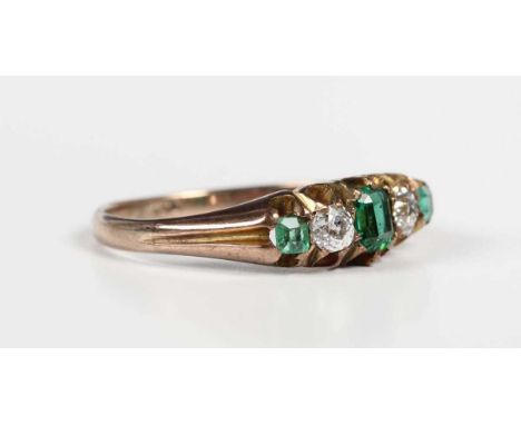 A gold, diamond and green gem set ring, mounted with two old cut diamonds between three green gemstones, detailed ‘9c’, weigh