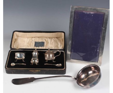 A George V silver three-piece condiment set, comprising mustard, pepper caster and salt with two condiment spoons, Birmingham