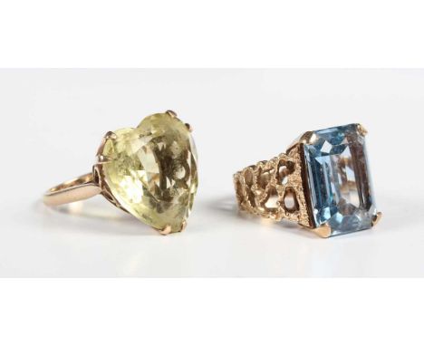 A gold ring, claw set with a cut cornered rectangular step cut synthetic blue spinel between pierced shoulders, detailed ‘9ct