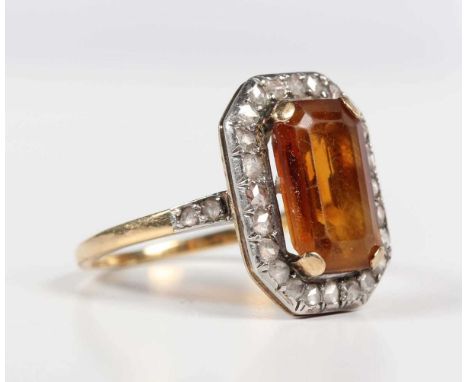 A gold and silver set, citrine and diamond cluster ring, claw set with the cut cornered rectangular step cut citrine within a