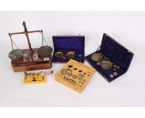 Two cased balancing scales, a balance scale on stand and box of mixed weights.