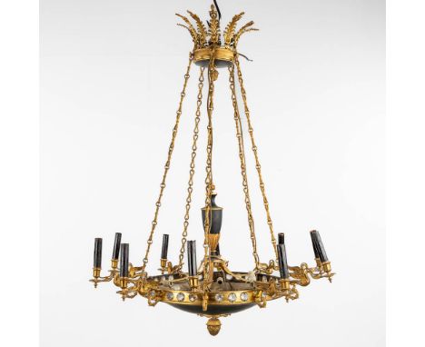 A chandelier, brass in Empire style with swan figurines, circa 1960.&nbsp;10 points of light. Finished with a&nbsp;black pati
