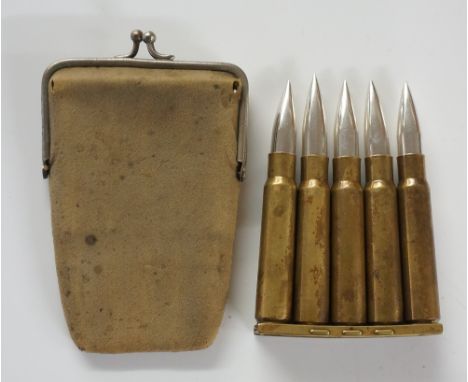 An unusual bullet clip necessaire set comprising five "bullets", three containing manicure tools, one with button hook and on